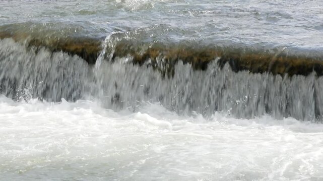 Water flowing over a river weir dam