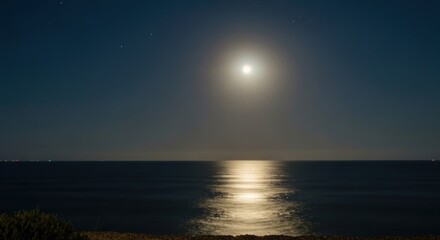 Obraz premium Night seascape under a bright full moon, with shimmering water reflecting the lunar glow