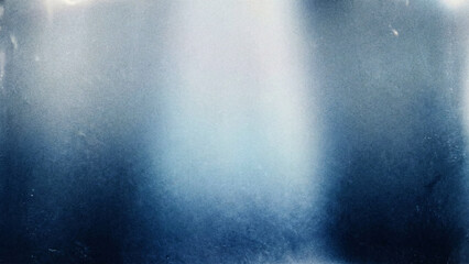 Obraz premium A moody and atmospheric abstract background with a heavy, grungy texture and soft, ethereal patches of blue and white light.