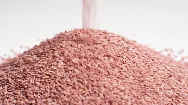 Pouring Coated Seeds Creating a Heap, Close Up