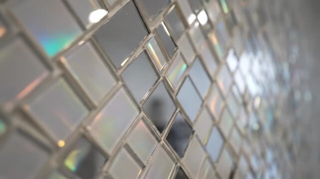 Shiny Decorative Mosaic Tile Wall - This video showcases a close-up of a shimmering mosaic tile wall, featuring small, square tiles with a reflective surface.