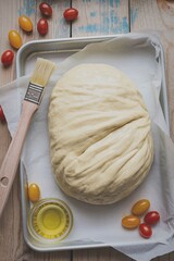 Fresh bread dough with olive oil and tomatoes