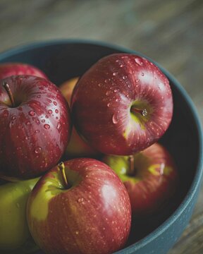 Fresh red apples in a dark bowl