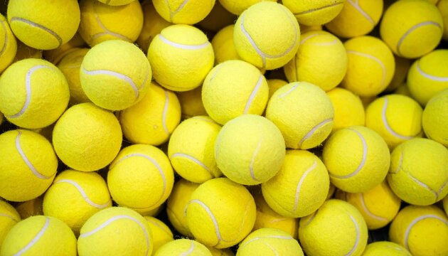 Tightly packed yellow tennis balls filling entire frame emphasizing abundance and sports preparation