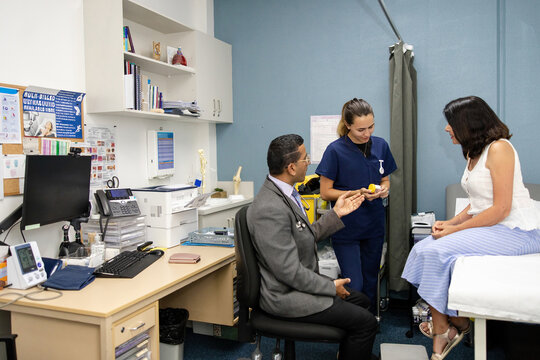 Clinical nurse handing out specimen container to senior patient
