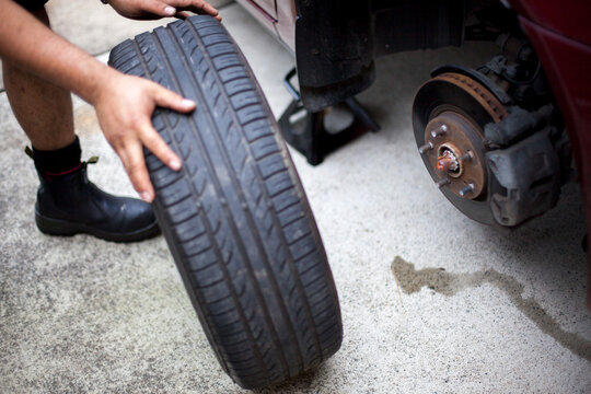 A mechanic inspects a tyre during a vehicle service.