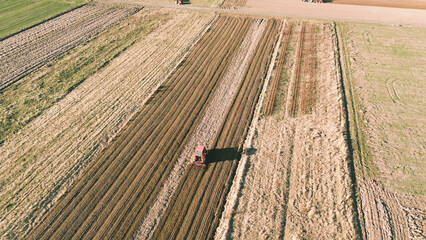 Dusty tractor working on agricultural land