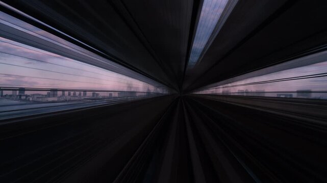 POV motion blur of train crossing the Rainbow Bridge toward Tokyo skyline.