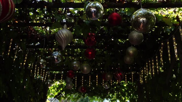 Christmas baubles hanging randomly in a variety of shapes and colors sway gently. It creates a really cool, beautiful perspective.