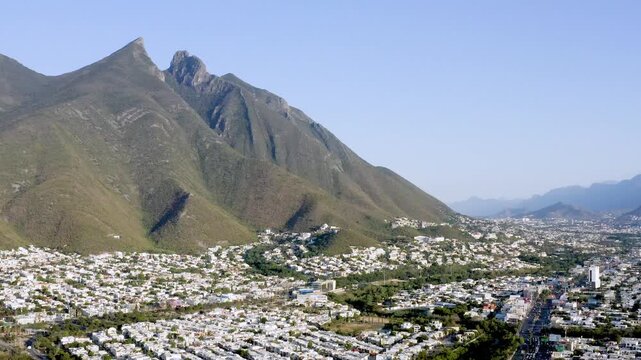 Scenic aerial drone footage capturing Cerro de la Silla overlooking the countryside near Monterrey, Mexico. The shot highlights the contrast between the iconic mountain formation and surrounding rural