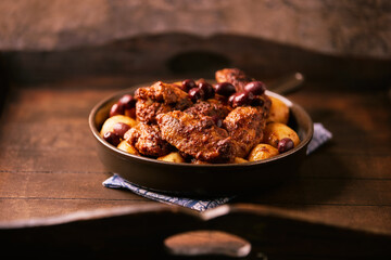 Fried chicken wings with potatoes on a rustic background. Soft focus.
