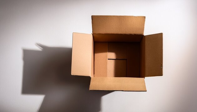 Open Empty Cardboard Box Casting A Shadow On A White Surface Top Down Perspective