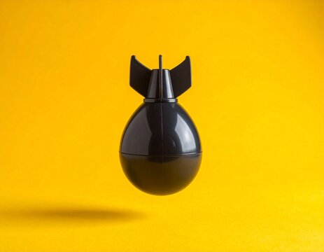 Floating toy atom bomb with exaggerated rounded shape and glossy plastic surface on vibrant yellow background, conceptual object against solid color