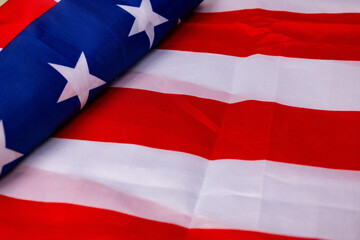 American flag with red and white stripes laid flat on a surface highlighting stars and colors