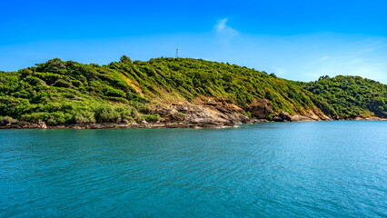 Obraz premium Panoramic view of the lush tropical coastline of Koh Samed island with turquoise waters and a clear blue sky