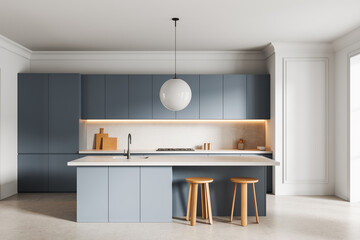 Modern minimalist kitchen interior with blue cabinets, white countertop, wood stools, and pendant...
