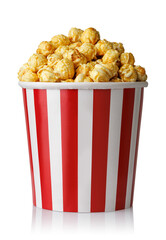Caramelized popcorn in red and white striped paper bucket isolated