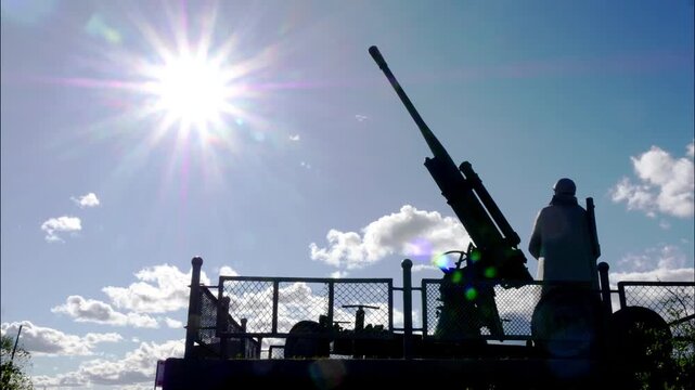 MURMANSK, RUSSIA : Monument to the soldiers who liberated the Soviet Arctic in World War II. Dark silhouettes of Alyosha and an anti-aircraft gun against the background of the sun. Timelapse.