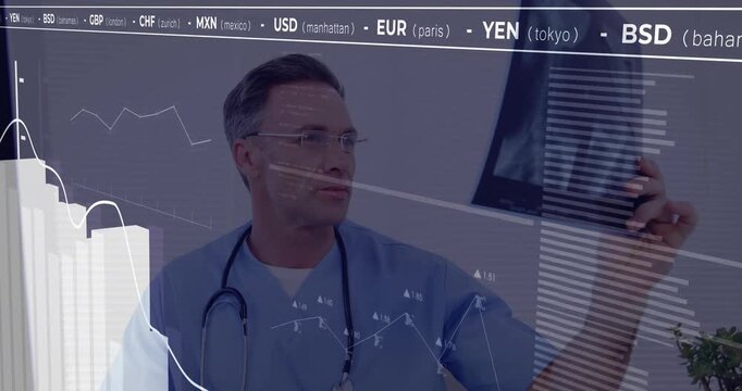 Medical professional staring screen then lifting Xray film examining while currency graphs updating