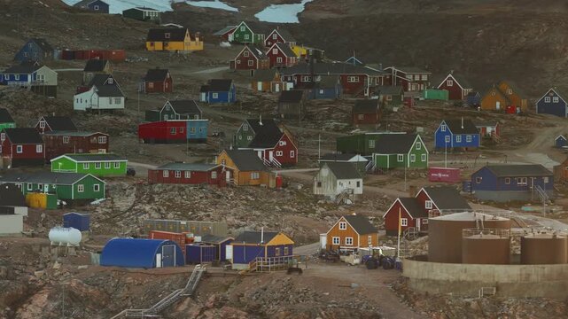 A drone orbits around colorful Iqqortoormiit, Greenland houses