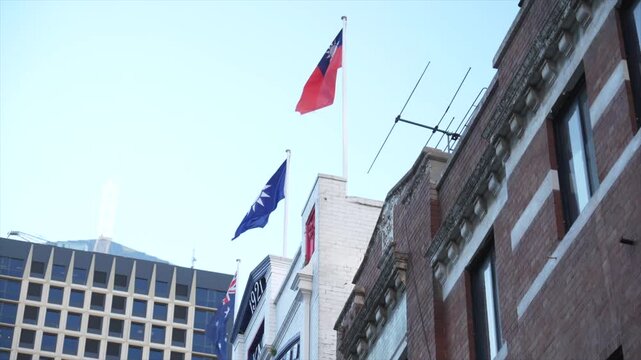 Flags flying above buildings in Chinatown Haymarket, Sydney CBD, including the Republic of China Taiwan flag and Blue Sky White Sun flag.
