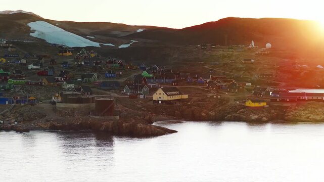 Iqqortoormiit, Greenland being washed in early morning sun. A long lens provides parallaxing layers of the town.