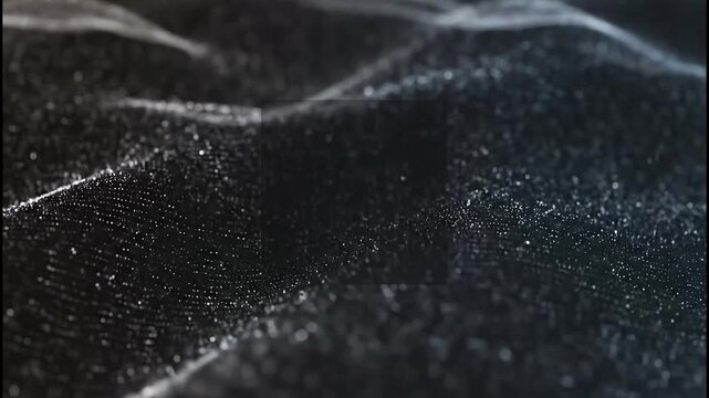 Close-up of rough black textured surface with white speckles and scratch lines showing rugged detail