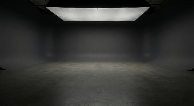 Photorealistic empty dark cyclorama studio interior with single overhead softbox and copy space