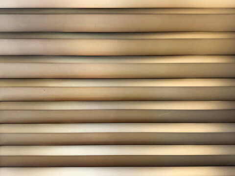 Natural gold metallic metal plate fluted panel or metal cladding slats. Beautiful elegant and luxurious corrugated metallic matte gold color paint. Seamless background texture.