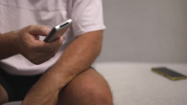 Man Peacefully Using Device, Person Calmly Browsing On Phone, Individual Comfortably Engaged With Mobile Device Indoors, Relaxed Individual Comfortably Checking Content On His Electronic Device
