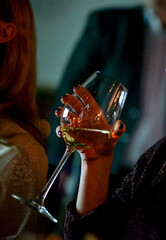 female hand with manicure holding a glass of white wine