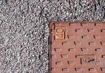 rusty sewer cap and tarmac