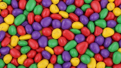 Colorful candy background with assorted jelly beans in red, green, purple, and yellow hues.