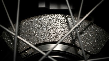 Close-up of a bicycle wheel with textured brake disc and metal spokes.