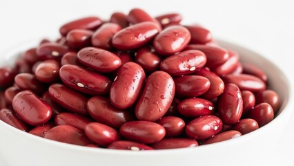 A bowl filled with red kidney beans on a white background.