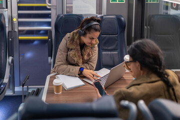 Woman working on laptop while traveling on train
