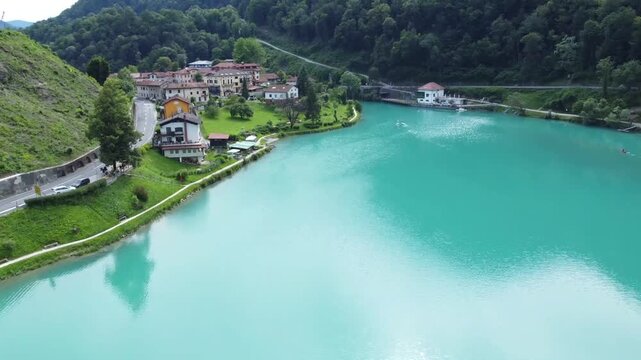 Drone shot of emerald Soca river and traditional houses in Most na Soci.