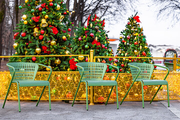 an outdoor chair against the backdrop of a Christmas tree. photo zone in the park at Christmas....