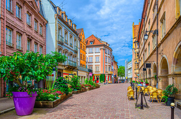Pedestrian street Grande Rue with old colorful houses, street restaurant cafe and medieval building Protestant presbytery in old town Colmar city historic centre, Alsace Grand Est region, France