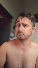 Naklejka premium Vertical photo Contemplative individual reviews possible hairstyle and facial grooming styles, Person carefully evaluates different hairstyle options and facial trimming choices in bathroom setting