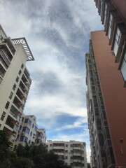 Fototapeta premium Tall apartment buildings under a cloudy sky, urban residential scene