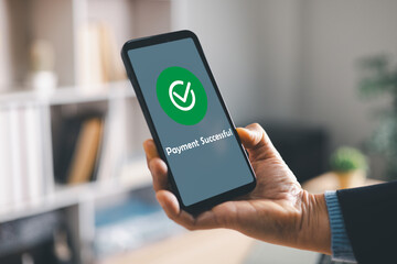 Hand holding smartphone showing payment successful screen with check mark, confirming secure mobile transaction for ecommerce purchase, fintech banking app, cashless digital wallet receipt.