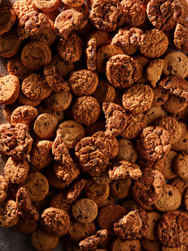Cookies of various shapes and sizes fill the surface. They are baked and browned, showing signs of being freshly made. The setting suggests a casual occasion for enjoying treats