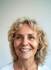 Cheerful senior woman with short gray hair and bright teeth, representing healthy aging, dental care, and joyful living.