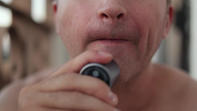 Person with intense expression efficiently defines his jaw outline with electric shaver, Man concentrating deeply shapes and refines his jawline using compact electric razor quickly and accurately