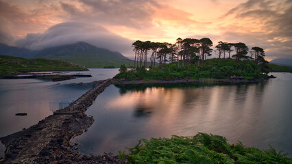 Obraz premium Dramatic Sunrise over Twelve Pines Island on Derryclare Lough in Connemara, County Galway, Ireland, Featuring Misty Mountains and Reflective Water, travel scenic landscape background