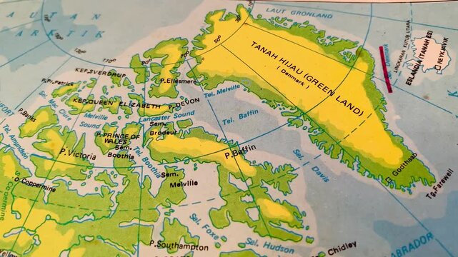 4K top view close-up of a vintage world map showing Greenland labeled Tanah Hijau. Sharp focus and aged paper texture create a calm, educational mood. Ideal for history, geography, travel, and documen