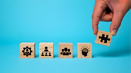 Assembling a team of professionals with diverse skills and a clear vision for business success, represented by icons on wooden blocks, with a puzzle piece completing the set