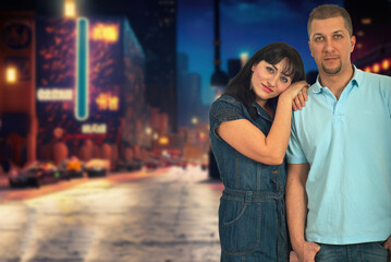 A man and woman are standing on a city street, with the man wearing a blue shirt