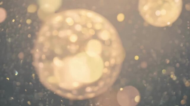 Defocused golden light circles moving softly like champagne bubbles or festive Christmas lights.